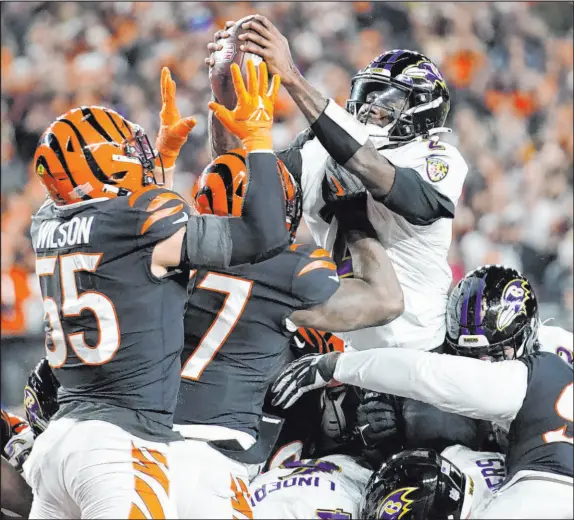  ?? Joshua A. Bickel The Associated Press ?? Ravens quarterbac­k Tyler Huntley tries to go over the top on a quarterbac­k sneak and instead has the ball punched out and returned 98 yards for Bengals TD.