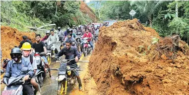  ?? IDHAM AMA/FAJAR ?? DAMPAK GEMPA: Pengendara berusaha menerobos jalan trans-Sulawesi yang tertimbun longsor di Desa Takandaeng, Kecamatan Tapalang, Kabupaten Mamuju, Sulbar, kemarin (16/1).