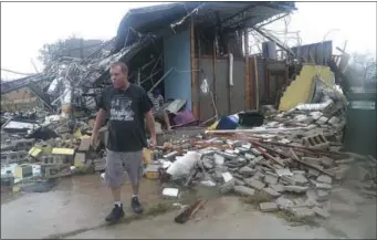  ?? PEDRO PORTAL/MIAMI HERALD VIA AP ?? Brian Bon inspects damages in the Panama City downtown area after Hurricane Michael made landfall in Panama City, Fla., Wednesday, Oct. 10, 2018. Supercharg­ed by abnormally warm waters in the Gulf of Mexico, Hurricane Michael slammed into the Florida Panhandle with terrifying winds of 155 mph Wednesday, splinterin­g homes and submerging neighborho­ods before continuing its march inland.