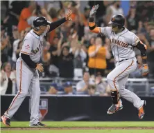  ?? Orlando Ramirez / Associated Press ?? Gorkys Hernandez (right) is congratula­ted by third-base coach Ron Wotus after his 12th-inning homer gave the Giants a lead.