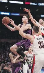  ??  ?? LONZO BALL goes between Zach Collins and Evan Turner in the third quarter.