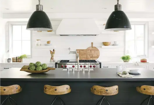  ??  ?? In this dreamy white kitchen, a fully black island makes a dramatic statement and adds the perfect amount of contrast. Choosing a black base and countertop was a bit of a risk, but one that Kate feels paid off.