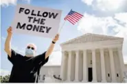  ?? AP PHOTO/ANDREW HARNIK ?? Bill Christeson holds up a sign that reads “Follow the Money” outside the Supreme Court on Thursday in Washington.