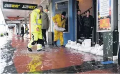  ?? PHOTO: STEPHEN JAQUIERY ?? Wet November. . . Sandbags were used to protect shops in Mosgiel, and other properties in South Dunedin when extensive flooding hit the Taieri, pockets of Dunedin, and Roxburgh, Oamaru and Balclutha late last month. Dave Mitchell (right) and Tony Vaas were among those sandbaggin­g shops at Mosgiel.