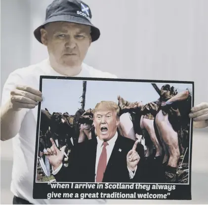  ??  ?? 0 A protester shows what he thinks Scotland makes of Donald Trump