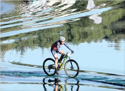  ?? PICTURE: CHRIS WESTGARTH-TAYLOR ?? Candice Neethling rides across the floating bridge spanning a small dam midway through yesterday’s eighth stage of the joBerg2C. Neethling and partner Darren Lill lie second in the mixed category, but halved the lead of Catherine Williamson and Johan...