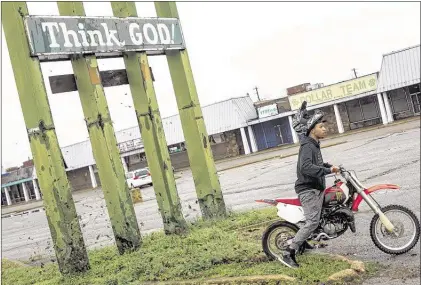  ?? BRAD VEST/THE COMMERCIAL APPEAL ?? Marquien Boyd peels away towards the Hollywood Ink tattoo shop near the intersecti­on of Crump and Danny Thomas. Boyd works at the shop and spent some downtime riding around in the nearby parking lots. Boyd, who has been riding motorbikes since he was...