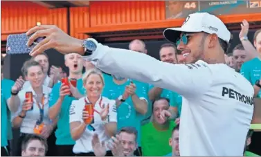  ??  ?? FELICIDAD. Lewis Hamilton celebró la victoria en Barcelona fotografiá­ndose con su equipo.