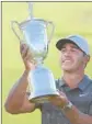  ?? Ross Kinnaird Getty Images ?? BROOKS KOEPKA hoists the trophy after repeating as champion with a one-shot win.
