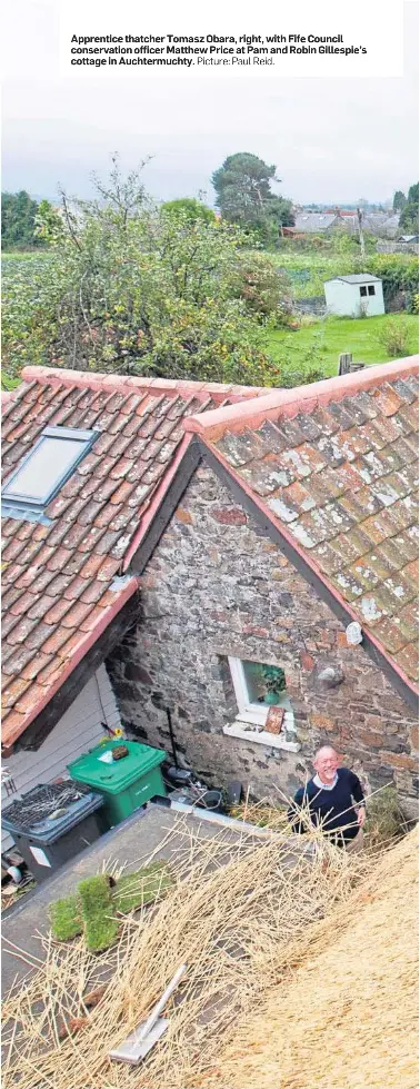  ?? Picture: Paul Reid. ?? Apprentice thatcher Tomasz Obara, right, with Fife Council conservati­on officer Matthew Price at Pam and Robin Gillespie’s cottage in Auchtermuc­hty.