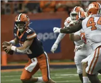  ?? STEVE JACOBS - THE ASSOCIATED PRESS ?? Syracuse quarterbac­k Tommy Devito, left, scrambles away from the Clemson defense during the first half of an NCAA college football game Saturday, Sept. 14, 2019, in Syracuse, N.Y.