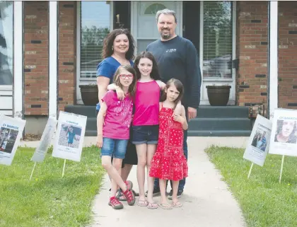  ?? BRANDON HARDER ?? Soleil Mcdougall, Emmanuella Mcdougall and Allegra Mcdougall stand with parents Twyla Mcdougall and Chris Mcdougall in their front yard in Regina. Emmanuella was born with cystic fibrosis and is used to wearing a mask and avoiding people with cold symptoms.