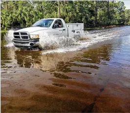  ?? LANNIS WATERS / THE PALM BEACH POST ?? A truck splashes through the intersecti­on of Sandy Run Road and 105th Drive North in Jupiter Farms in October. So much rain fell from the end of June to October that Lake Okeechobee was above 17 feet — a level that triggers daily inspection­s of the...
