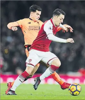  ?? FOTO: GETTY IMAGES ?? Özil y Coutinho, en pugna por un balón Ambos marcaron ayer en el Emirates