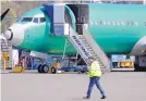  ?? TED S. WARREN/ASSOCIATED PRESS ?? A worker walks past a Boeing 737 MAX 8 airplane being built for Oman Air at Boeing’s assembly facility in Renton, Washington, earlier this year.