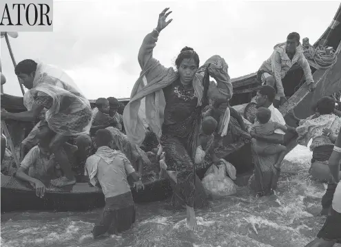  ?? DAN KITWOOD / GETTY IMAGES ?? Rohingya refugees jump from a wooden boat as it begins to tip over on Tuesday, after travelling from Myanmar, in Dakhinpara, Bangladesh.