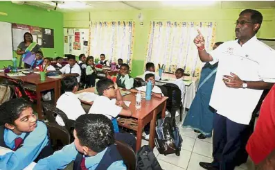  ??  ?? Pep talk: Kamalanath­an (right) giving words of encouragem­ent to SJKT Gelang Patah students during his visit to the school.