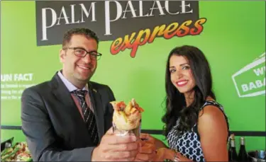  ?? MITCH HOTTS — THE MACOMB DAILY ?? Ahmad Hodroj and his wife, Fatima, show off a chicken shwarma sandwich on Wednesday during a grand opening celebratio­n for Palm Palace Express inside of the Mall at Partridge Creek in Clinton Township.