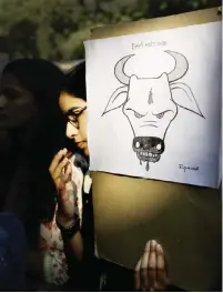  ?? — AP ?? NEW DELHI: A student activist holds a placard during a protest denouncing the killing of a 52-year-old Muslim farmer Mohammad Akhlaq by villagers upon hearing rumors that the family was eating beef, a taboo for many among India’s majority Hindu...