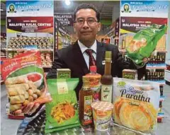  ??  ?? NOOR Hisham menunjukka­n produk yang dijual di Singapura.