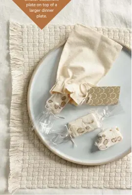  ??  ?? Layer it: with your place settings, try a smaller statement plate on top of a larger dinner
plate.