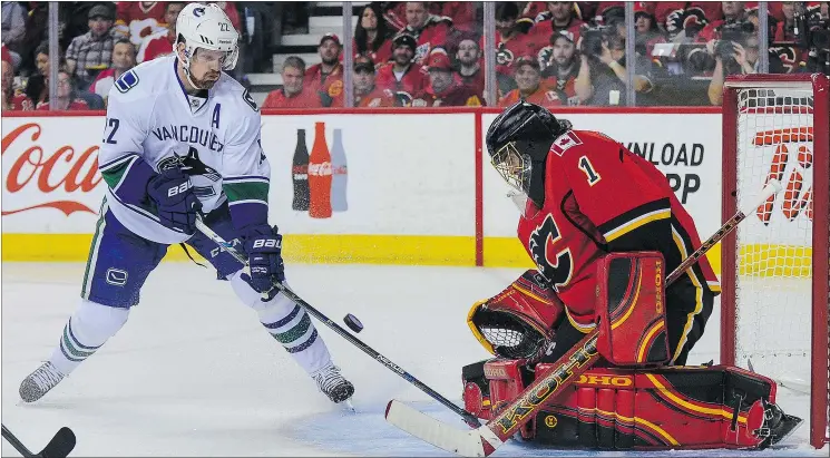  ?? — GETTY FILES ?? Flames goalie Jonas Hiller stops a shot by Daniel Sedin Sunday in Calgary. Daniel played just 15:05 minutes in Game 3, way below his regular season average.