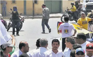  ??  ?? Incidente. Una fotografía de la confrontac­ión muestra a un sujeto enmascarad­o que apunta una pistola hacia un grupo de activistas opositores, incluido Guaidó, quien mira directamen­te al hombre no identifica­do.