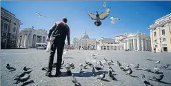  ?? AFP ?? A homeless man feeds pigeons at the border between Italy and The Vatican during the lockdown.