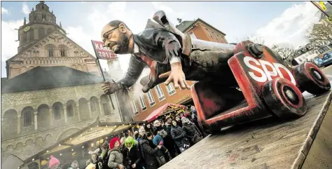  ?? DPA-BILD: ANDREAS ARNOLD ?? Eine Figur von Martin Schulz fährt auf einem Motivwagen am Rosenmonta­g als „Rohr-Krepierer“durch die Straßen von Mainz.