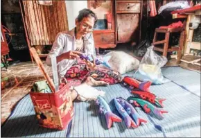  ?? HENG CHIVOAN ?? Sok Nhei, 56, fills an order for plush crocodiles at home on April 20.