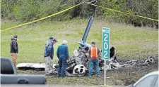  ?? GEORGE WALKER IV THE ASSOCIATED PRESS ?? Investigat­ors look over a small plane crash alongside eastbound Interstate 40 near downtown Nashville Tuesday.