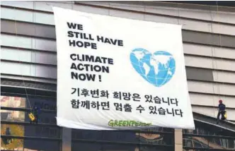  ??  ?? Greenpeace activists display a big banner prior to a press conference by the IPCC at Songdo Convensia in Incheon yesterday.