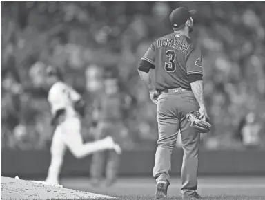  ?? RON CHENOY/USA TODAY SPORTS ?? The Diamondbac­ks’ Daniel Descalso watches as the Colorado Rockies’ Carlos Gonzalez the bases in the fourth inning Wednesday at Coors Field. Descalso, who is primarily an infielder, allowed three runs on four hits in 22⁄3 innings of relief on the mound.