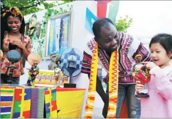  ?? YU FANGPING / FOR CHINA DAILY ?? A child checks out a figurine displayed by internatio­nal students from Ghana on the campus of China University of Petroleum in Qingdao, Shandong province, on Tuesday. An exhibition highlighti­ng China-Africa cooperatio­n and the Belt and Road Initiative was held to commemorat­e the 65th anniversar­y of the university’s founding.