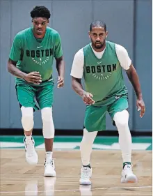  ?? CHARLES KRUPA THE ASSOCIATED PRESS ?? Celtics draft pick Robert Williams, left, and guard Brad Wanamaker work on stepping drills during a practice in Boston on Tuesday.