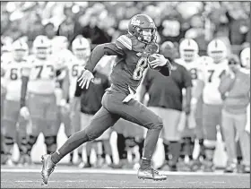  ?? AP/KEITH SRAKOCIC ?? Pittsburgh freshman quarterbac­k Kenny Pickett runs past the Miami bench on his way to a 22-yard touchdown run in the second half Friday in Pittsburgh. Pickett ran for two touchdowns and threw for another as Pittsburgh upset No. 2 Miami 24-14.