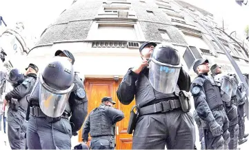  ??  ?? Argentina’s Federal police officers guard the entrance of a building where Kirchner owns a flat, during a raid as part of the so-called corruption notebooks case, in Recoleta neighbourh­ood, Buenos Aires. — AFP photo