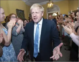  ?? STEFAN ROUSSEAU — POOL PHOTO VIA AP ?? Britain’s new prime minister, Boris Johnson, is welcomed into No. 10Downing St. by staff on Wednesday. Johnson vowed the U.K. will leave the European Union on Oct. 31.