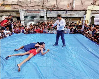  ?? REUTERS ?? Wrestlers fight during an amateur wrestling match inside a makeshift ring installed on a road by locals as part of Diwali celebratio­ns, in Kolkata on Wednesday.