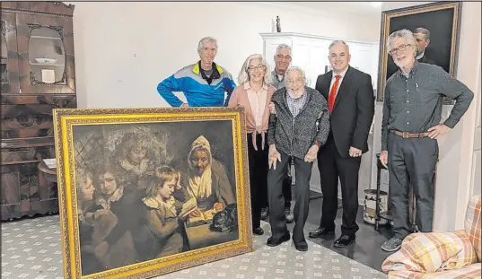  ?? The Associated Press ?? Special Agent Gary France, second right, Dr. Francis Wood and Wood’s children stand next to the John Opie painting — “The Schoolmist­ress” — that was stolen from Wood’s parents’ home in 1969. “This piece of art, what a history it’s had,” France said.