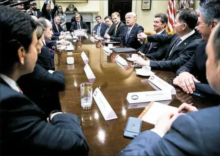  ?? Doug Mills/The New York Times ?? President Donald Trump shakes hands with Michael Dell, chief executive of Dell Technologi­es, during a breakfast with business leaders Monday in the Roosevelt Room of the White House.