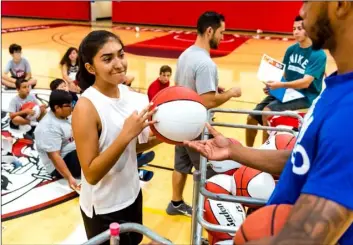  ?? VINCENT OSUNA PHOTOS ?? Andrea Herrera, 13, smiles as she receives a camp basketball and certificat­e of completion during the 2018 Imperial Valley College basketball camp on Thursday at the DePaoli Sports Complex in Imperial.