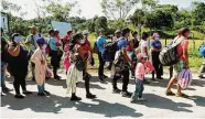  ?? Associated Press file photo ?? Migrants hoping to reach the U.S. line up before having documents checked in Corinto, Honduras.