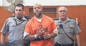  ?? MICHAEL SEARS / MILWAUKEE JOURNAL SENTINEL ?? Baron Walker waves to his family seated in the gallery as he enters the courtroom.