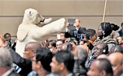  ??  ?? Durante la reunión un hombre se disfrazó de oso polar y caminó entre los delegados.