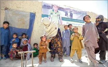  ?? DANIAL SHAH/THE NEW YORK TIMES ?? Gul Saima helps her 3-year-old son, Sayyad Karam, who was diagnosed with polio in April, the country’s only new case this year, outside their home in Dukki, Pakistan, on April 24.