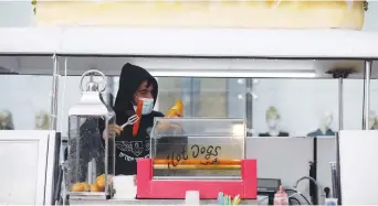  ?? (Amir Cohen/Reuters) ?? A VENDOR wears a protective face mask at a hotdog stand, in a shopping center in Ashdod on Tuesday.