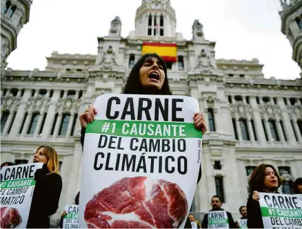  ?? Gabriel Bouys/AFP ?? Em Madri ativistas protestam contra o consumo de carne; pecuária é uma das causadoras do efeito estufa