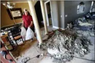  ?? GERALD HERBERT — THE ASSOCIATED PRESS ?? Castor Gay, who plays center for the Mosley High football team, cleans debris Friday from his heavily damaged home, in the aftermath of Hurricane Michael in Lynn Haven, Fla.