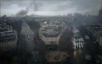  ?? KAMIL ZIHNIOGLU — THE ASSOCIATED PRESS ?? Avenues leading to the Arc de Triomphe are pictured from the top of the Arc de Triomphe on the Champs-Elysees avenue during a demonstrat­ion Saturday in Paris. A French protest against rising taxes and the high cost of living turned into a riot Saturday in Paris as police fired tear gas and water cannon in street battles with activists wearing the fluorescen­t yellow vests of a new movement.